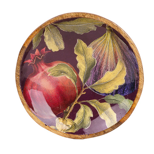 Overhead view of large mango wood bowl featuring figs, pomegranates and foliage on a rich burgundy background